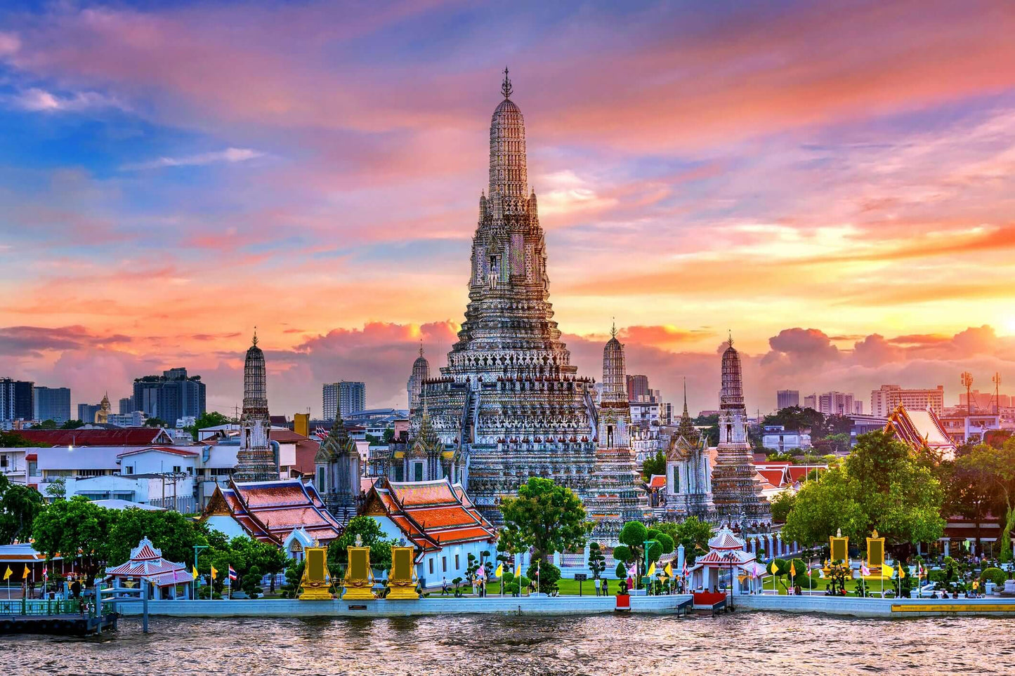 Stunning sunset view of Wat Arun temple in Bangkok, showcasing intricate design and vibrant colors.