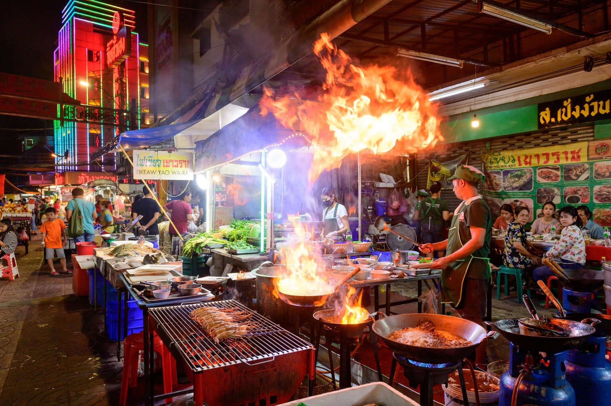 Vibrant Bangkok night market scene with street food vendors and colorful neon lights.