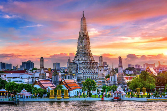 Stunning sunset view of Wat Arun temple in Bangkok, showcasing intricate design and vibrant colors.